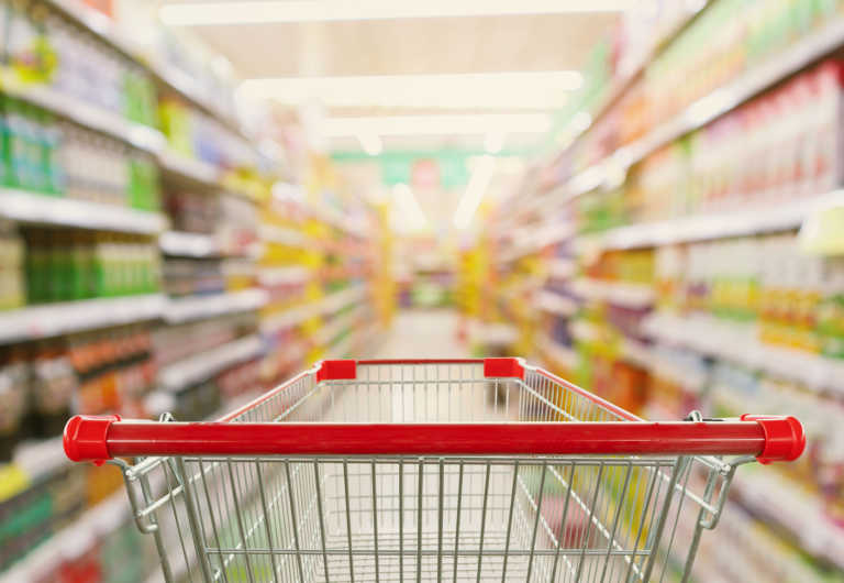 supermarket aisle interior blur background with empty red shopping cart