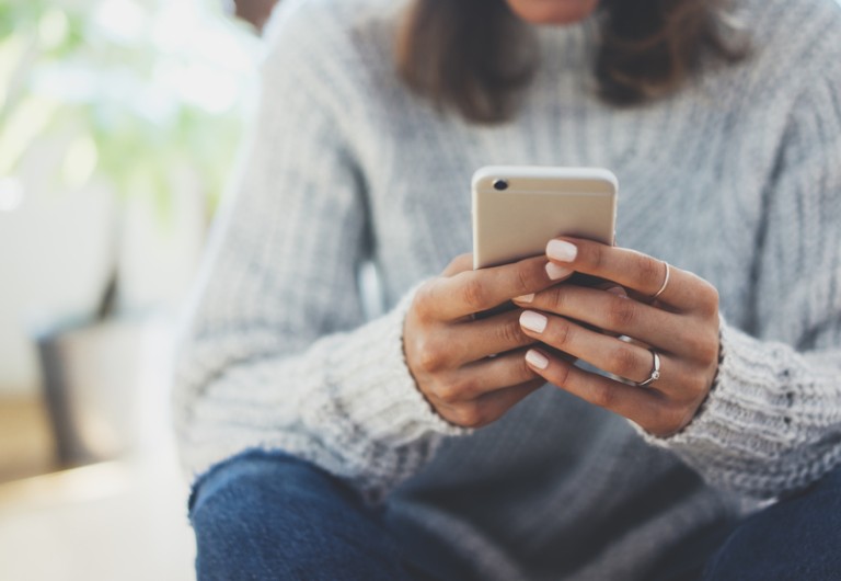 Seated woman looking at her mobile phone